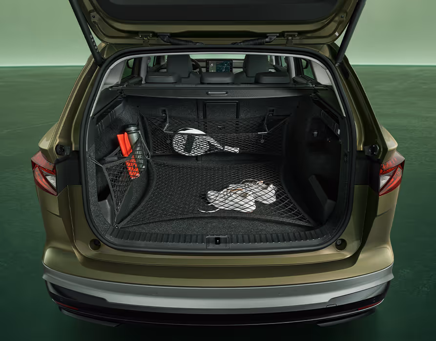 Blick in den geöffneten, leeren Kofferraum des Škoda Enyaq Coupé in der Farbe Moon-Weiß Perleffekt vor grünem Studiohintergrund. Das „Simply Clever“-Netzprogramm ist im Einsatz und sichert verschiedene Gegenstände wie einen Paddelschläger, Turnschuhe und eine Trinkflasche.