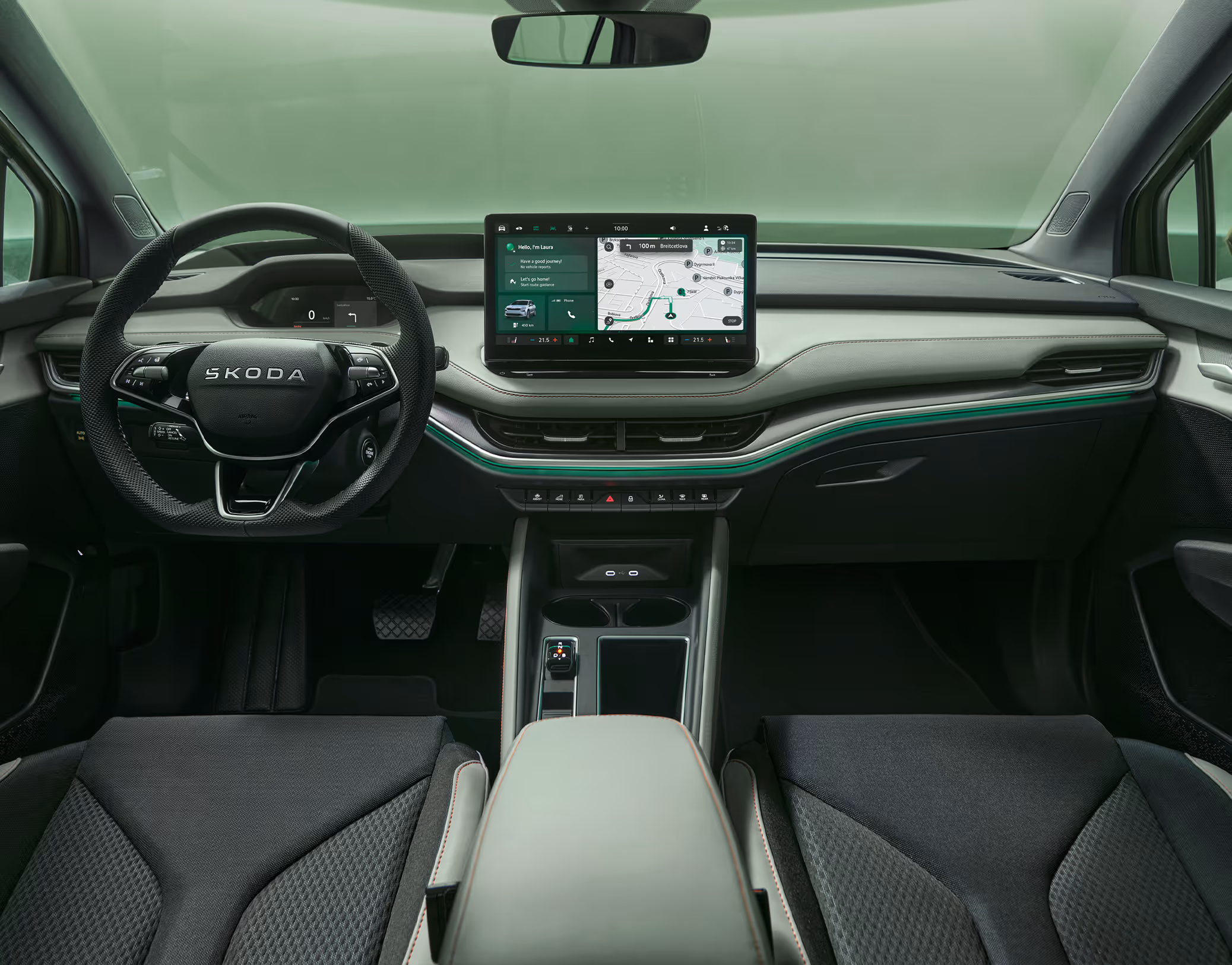 Blick über die Mittelarmlehne auf das Lenkrad, das Infotainmentsystem und das Armaturenbrett im Škoda Elroq in der Ausstattungslinie “Lodge”.