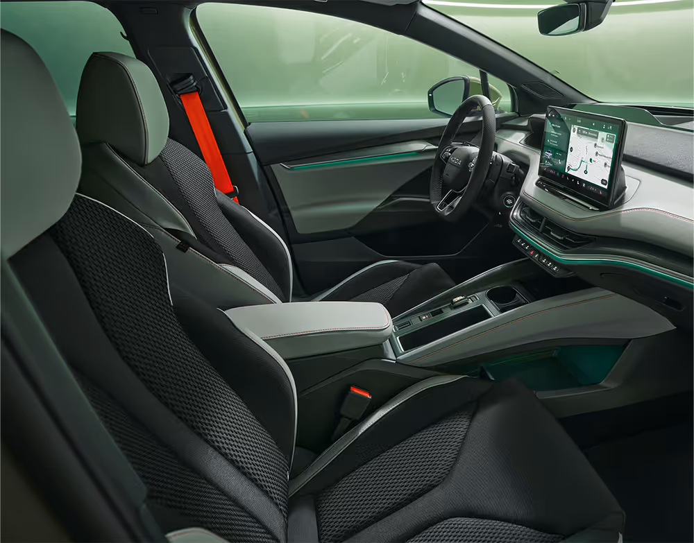 Beifahrer-Perspektive im Innenraum des Škoda Elroq in der Ausstattungslinie “Lodge”. Der Blick fällt auf das Lenkrad, das Digital Cockpit und den zentralen Infotainment-Bildschirm.