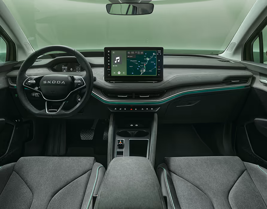 Blick über die Mittelarmlehne auf das Infotainmentsystem im Škoda Elroq mit der Ausstattungslinie “Studio”.