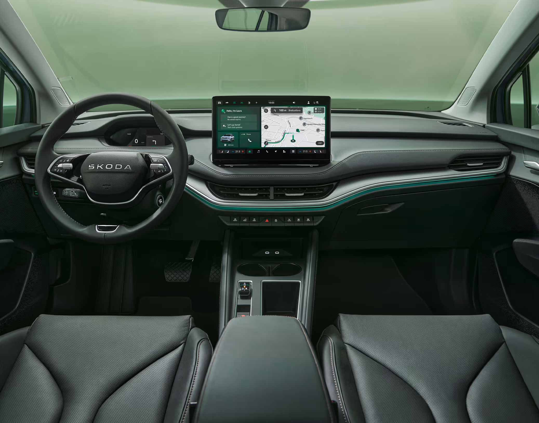 Blick über die Mittelarmlehne auf das Lenkrad, das Infotainmentsystem und das Armaturenbrett im Škoda Elroq. Türkise Ambient-Beleuchtung.