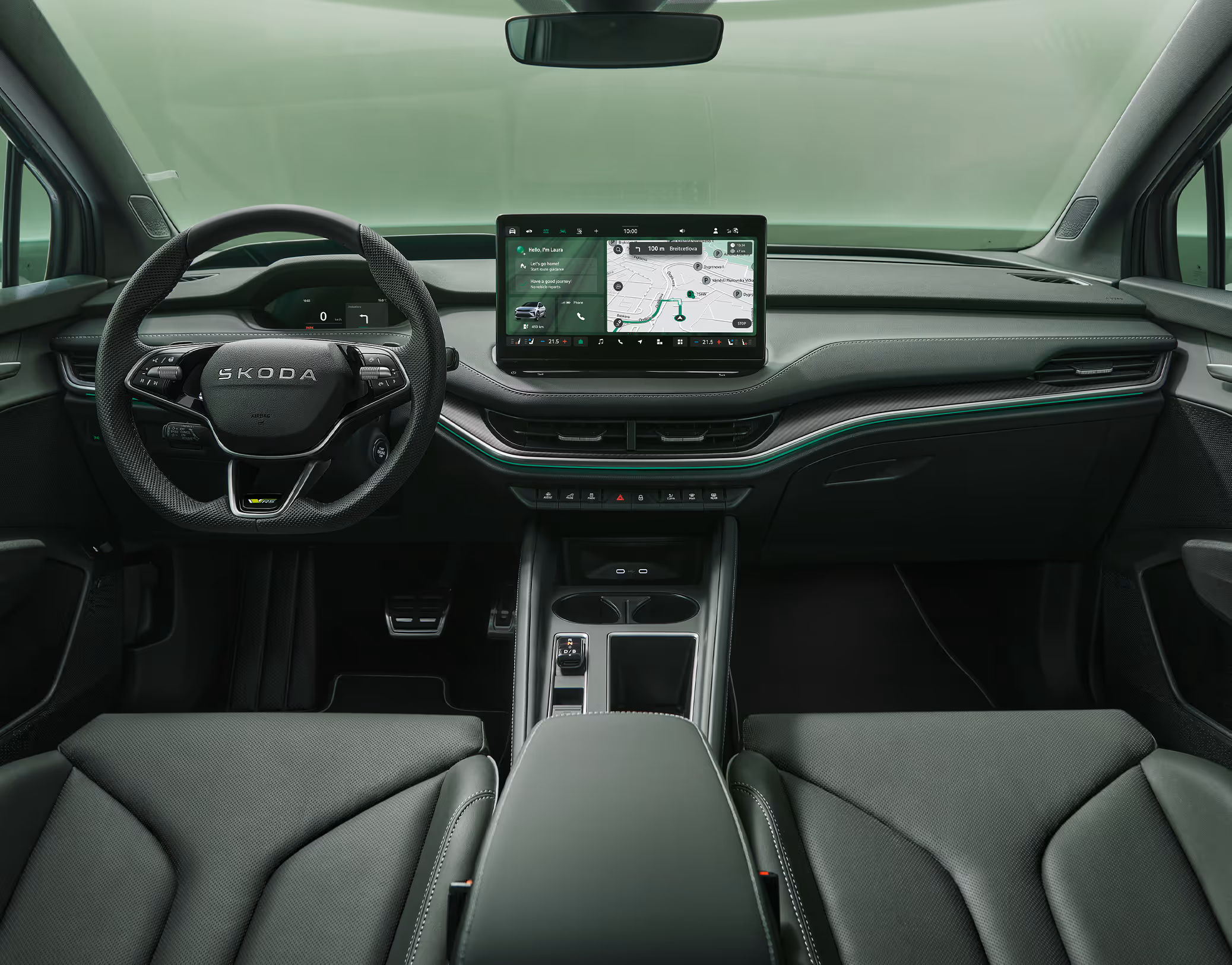 Eine symmetrische Weitwinkelaufnahme zeigt das Cockpit des Škoda Enyaq RS aus der Perspektive der Rücksitze. Das elegante Interieur der Design Selection „RS Suite“ besticht durch perforierte schwarze Lederbezüge und Dekor in Carbon-Optik sowie grüne Ambientebeleuchtung.