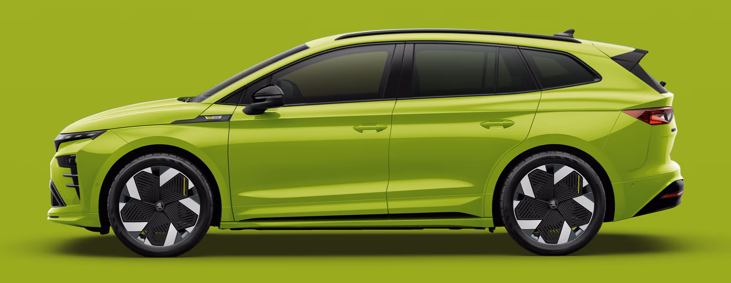 Seitenansicht eines Škoda Elroq RS in der Farbe Mamba-Grün mit 21 Zoll Felgen “Vision Anthrazit” vor einem einfarbigen Hintergrund in der Farbe der Fahrzeuglackierung.