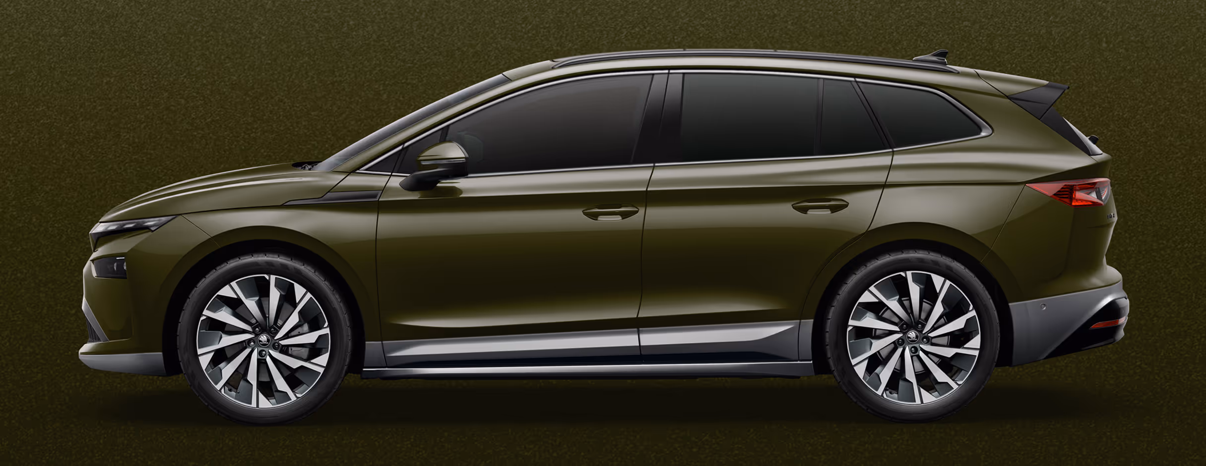 Seitenansicht eines Škoda Enyaq in der Farbe Olibo-Grün Metallic mit 21 Zoll Leichtmetallfelgen “Supernova” vor einem einfarbigen Hintergrund in der Farbe der Fahrzeuglackierung.