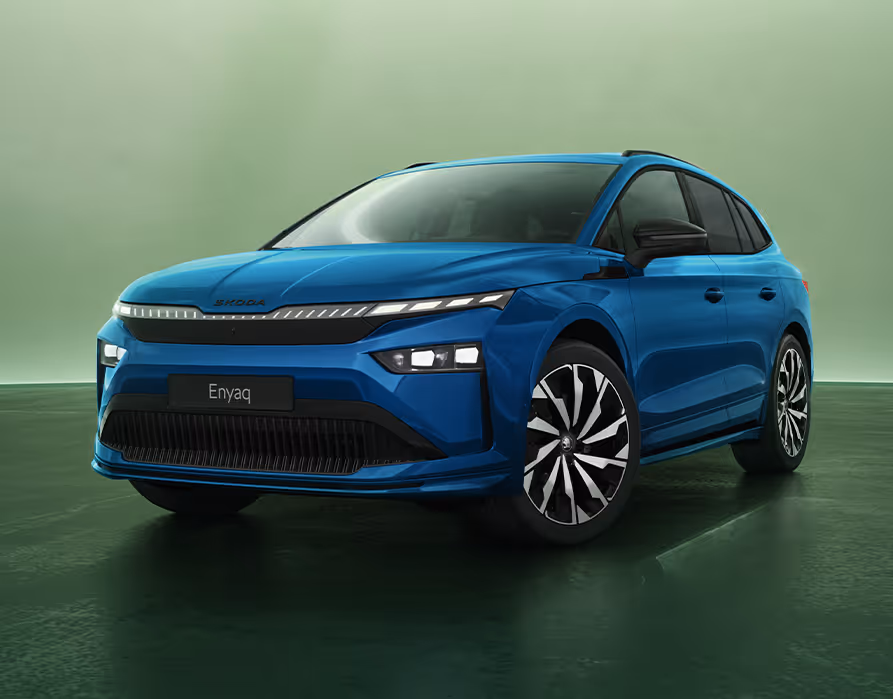 Dreiviertel-Frontansicht auf einen Škoda Enyaq Sportline in der Farbe Race-Blau Metallic vor einem grünen Studiohintergrund. Das dynamische Design wird durch das beleuchtete Crystal Face, die schmalen Voll-LED-Matrix-Scheinwerfer und die großen, zweifarbigen Leichtmetallfelgen betont.