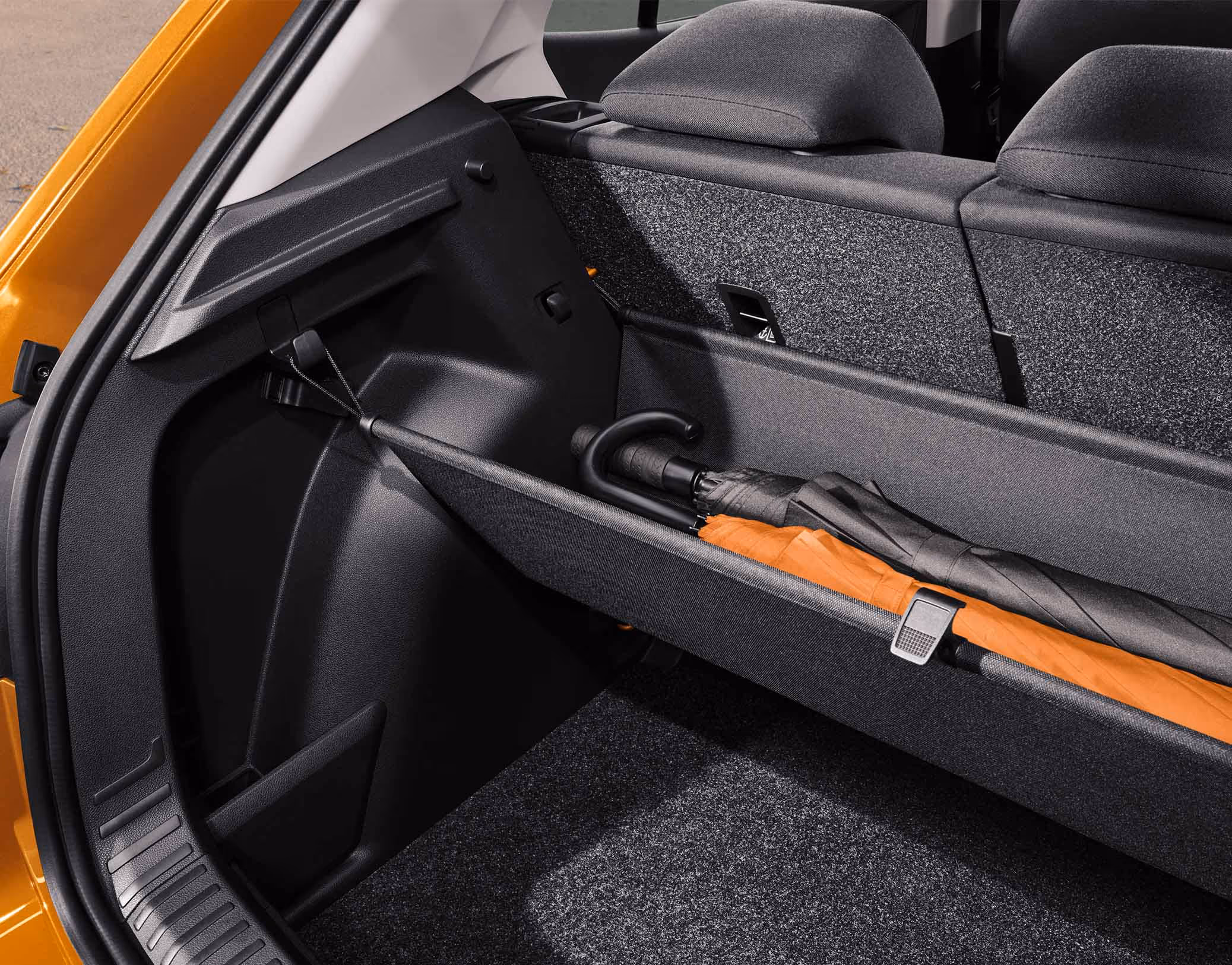 Unterhalb der Hutablage im Kofferraum des Škoda Fabia ist eine flexible Ablagetasche gespannt. In dieser hängenden Vorrichtung liegt ein großer Regenschirm. Befestigt ist das Fach über Haken an den Seitenwänden des Laderaums.