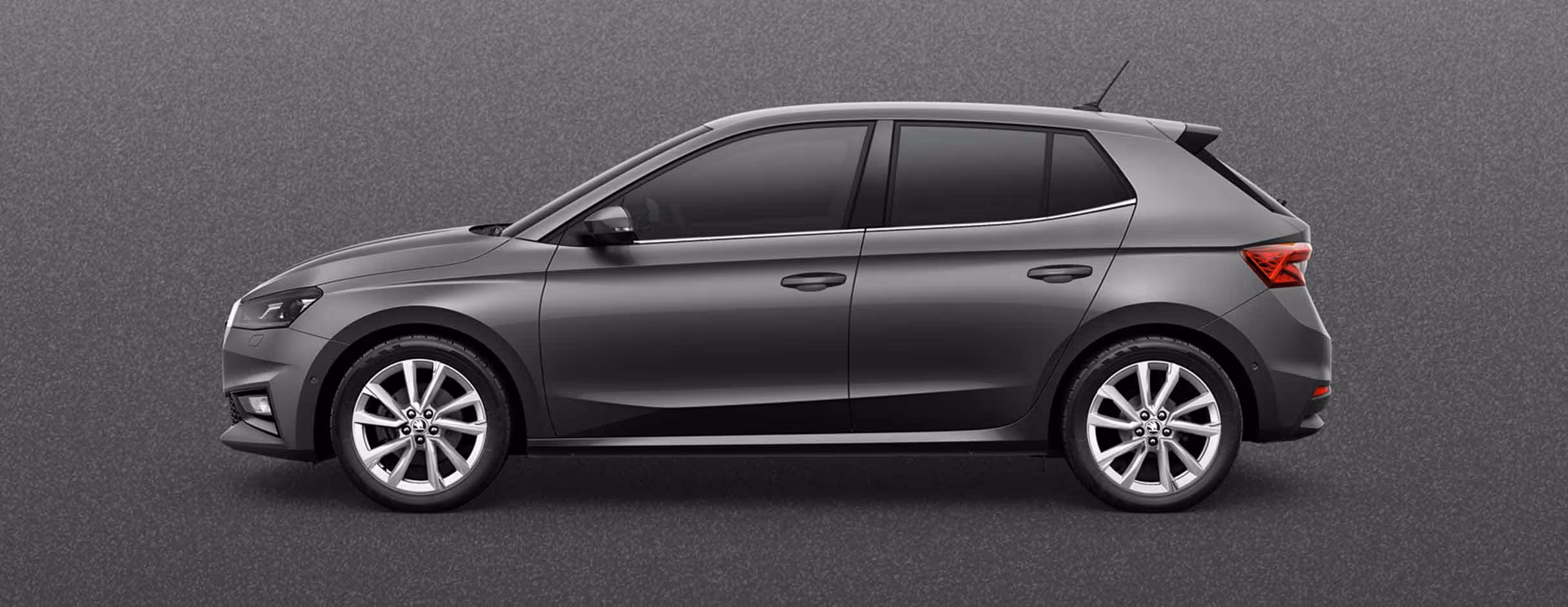 Seitenansicht eines Škoda Fabia in der Lackierung Graphite-Grau Metallic mit 17 Zoll Leichtmetallfelgen “Procyon silber“ vor einem einfarbigen Hintergrund in der Farbe der Fahrzeuglackierung.