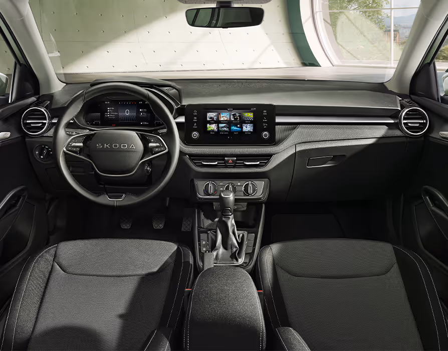 Ein Blick in den Innenraum des Škoda Fabia der Ausstattungslinie Selection präsentiert die Design Selection Loft. Charakteristisch sind die grauen Stoffbezüge mit Ziernähten am Armaturenbrett, die optisch auf die dunklen Sitze mit hellen Kontrastnähten abgestimmt sind. Das Cockpit umfasst zudem ein zweispeichiges Multifunktionslenkrad mit Chromelementen, ein freistehendes Infotainment-Display sowie eine gepolsterte Mittelarmlehne.
