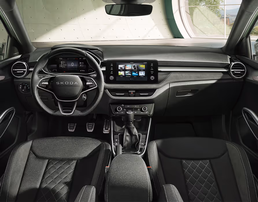 Ein Blick in den Innenraum des Škoda Fabia der Ausstattungslinie Selection präsentiert die sportliche Design Selection Dynamic. Im Fokus stehen die schwarzen Sportsitze mit Rautensteppung und das perforierte Dreispeichen-Sportlenkrad. Ergänzt wird das dynamische Ambiente durch die Edelstahlpedale, das digitale Kombiinstrument und das zentrale Infotainment-Display.