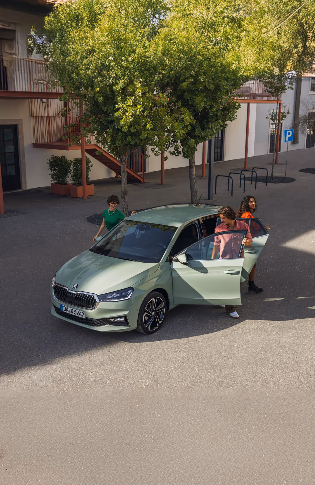 Das Cockpit des Škoda Elroq mit Blick auf das Lenkrad und den freistehenden 13-Zoll-Infotainmentbildschirm. Die grüne Ambientebeleuchtung setzt einen farbigen Akzent entlang des Armaturenbretts und der Türen.