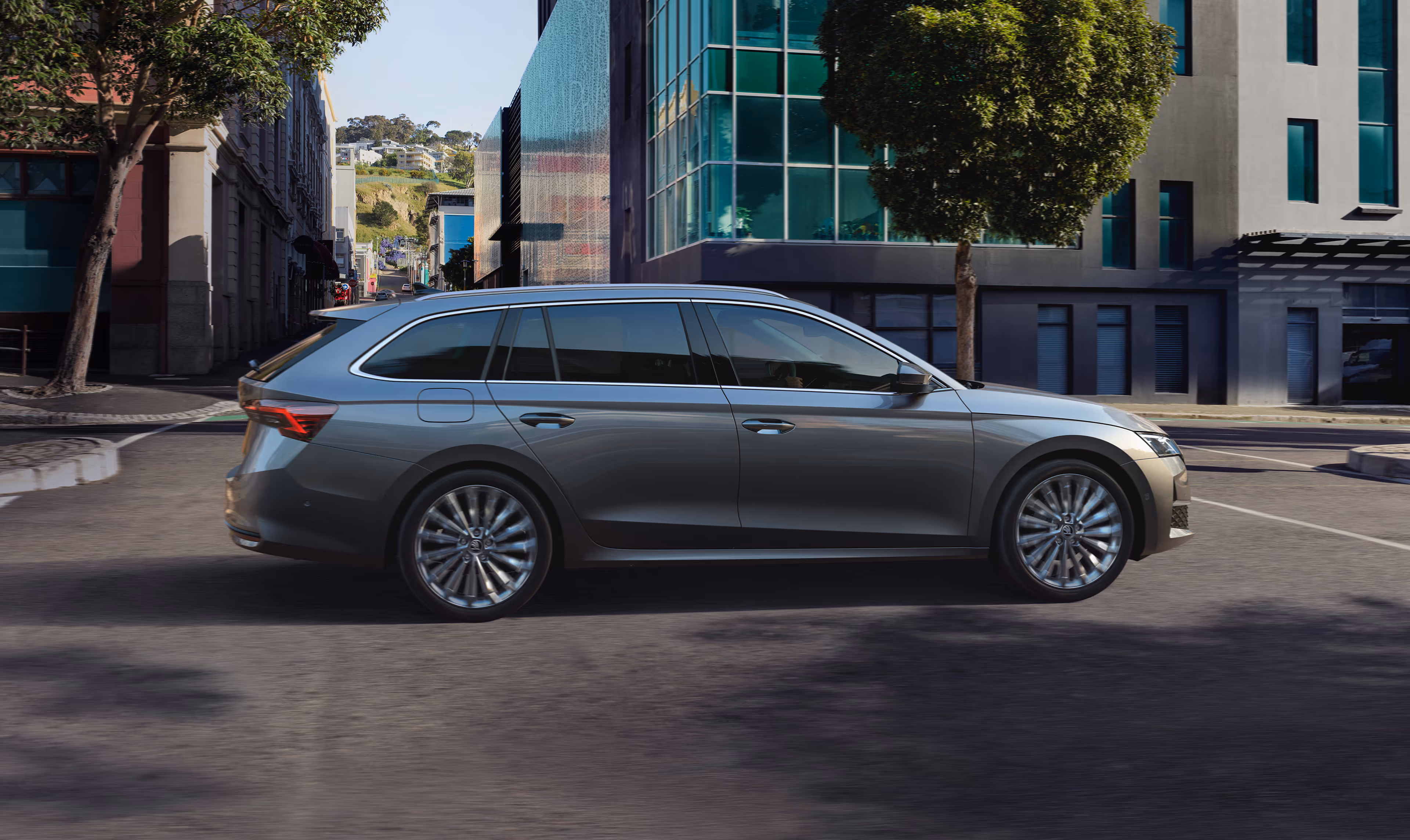 Heckansicht eines Škoda Elroq mit einem Fahrradträger auf der Anhängerkupplung vor grünem Studiohintergrund. Auf dem Träger sind zwei Fahrräder mit Škoda Schriftzug auf dem Rahmen montiert.