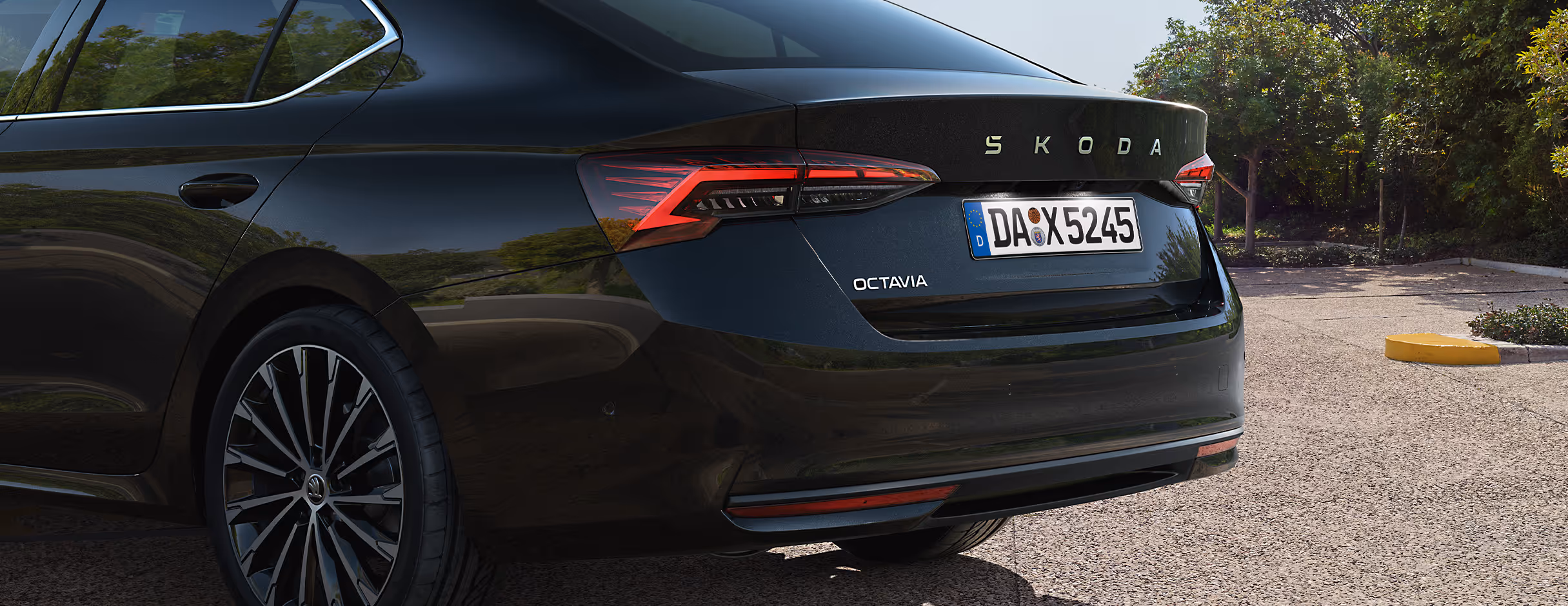 Eine Nahaufnahme zeigt die Heckpartie einer Škoda Octavia Limousine in der Lackierung Black-Magic Perleffekt. Die Aufnahme hebt das Design der Voll-LED-Heckleuchten und die markanten Schriftzüge auf der Heckklappe hervor.
