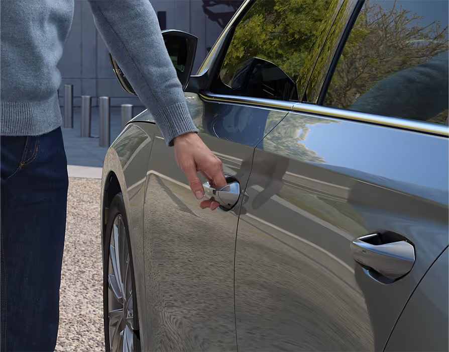 Eine Nahaufnahme zeigt einen Mann, der den Türgriff einer Škoda Octavia Limousine in der Lackierung Smokey Diamond-Silber Metallic ergreift.