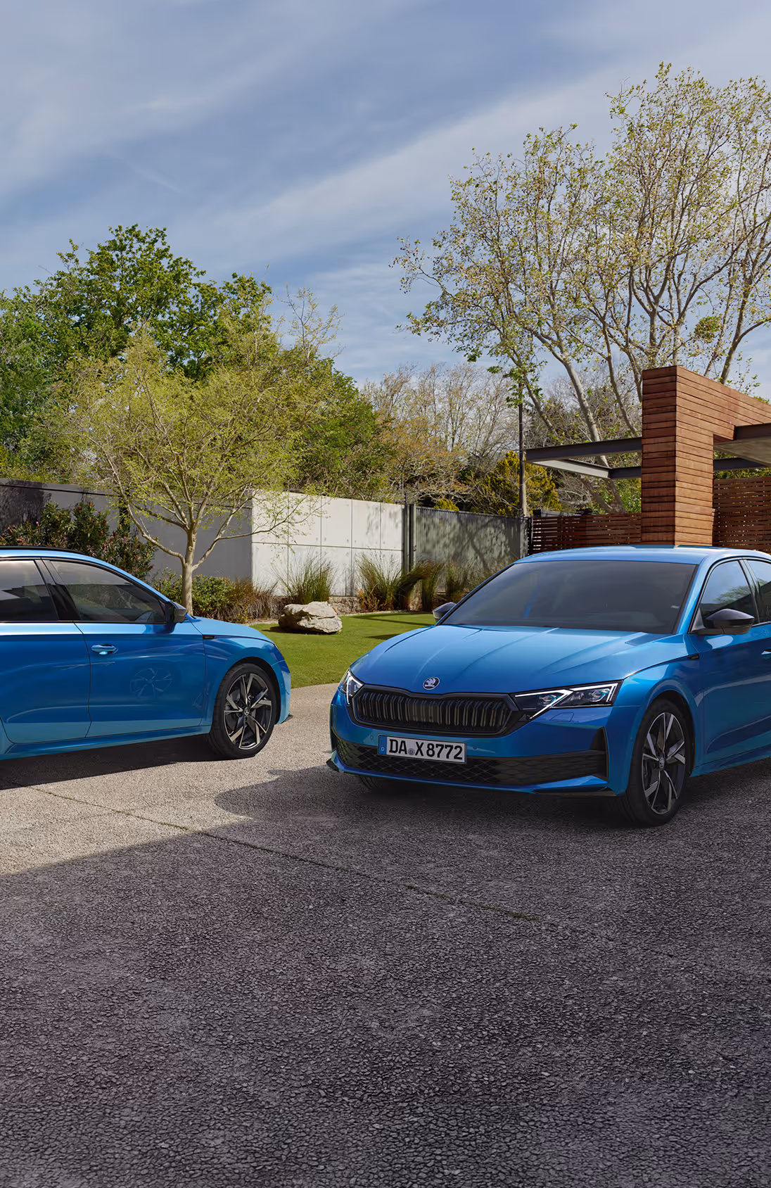 Frontalansicht des Škoda Elroq Sportline in der Farbe Race-Blau Metallic vor grünem Studiohintergrund. Das Fahrzeug zeichnet sich durch schwarze Designelemente am Kühlergrill und an der Frontschürze aus.