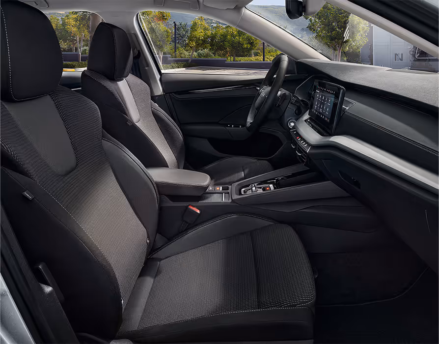 Beifahrer-Perspektive im Innenraum des Škoda Elroq in der Ausstattungslinie “Loft”. Der Blick fällt auf das Lenkrad, das Digital Cockpit und den zentralen Infotainment-Bildschirm.