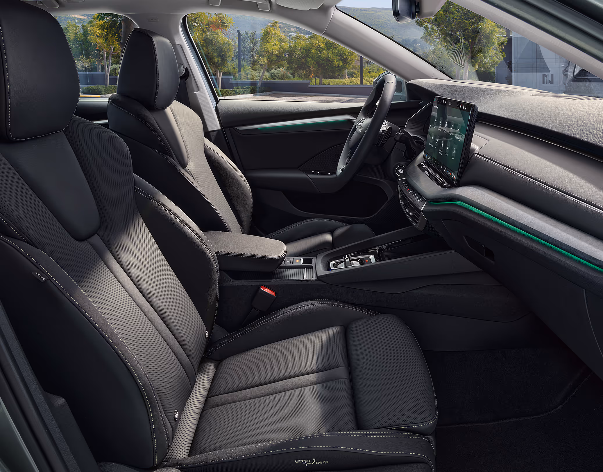 Beifahrer-Perspektive im Innenraum des Škoda Elroq. Der Blick fällt auf das Lenkrad, das Digital Cockpit und den zentralen Infotainment-Bildschirm.