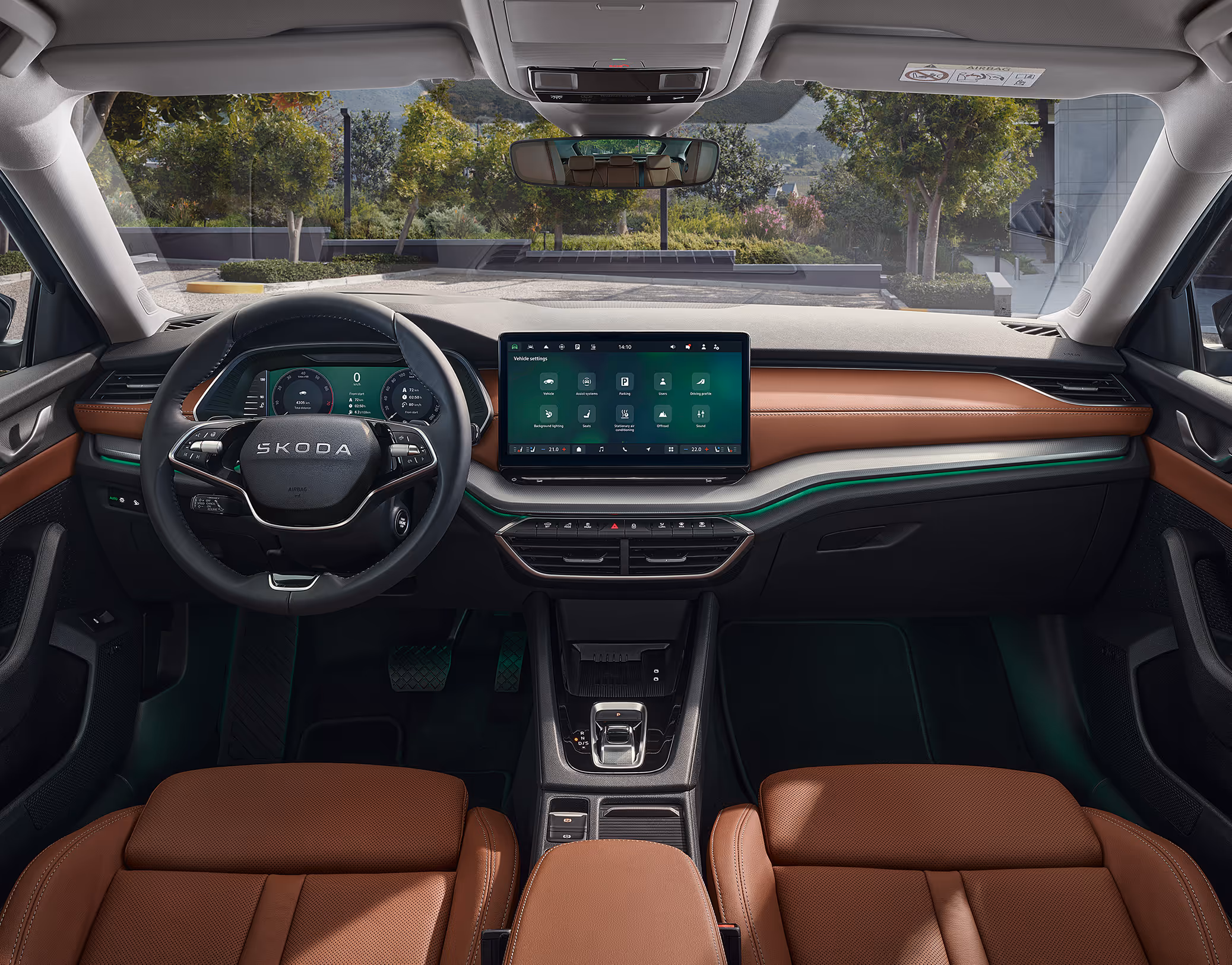 Blick über die Mittelarmlehne auf das Lenkrad, das Infotainmentsystem und das Armaturenbrett im Škoda Elroq. Türkise Ambient-Beleuchtung.