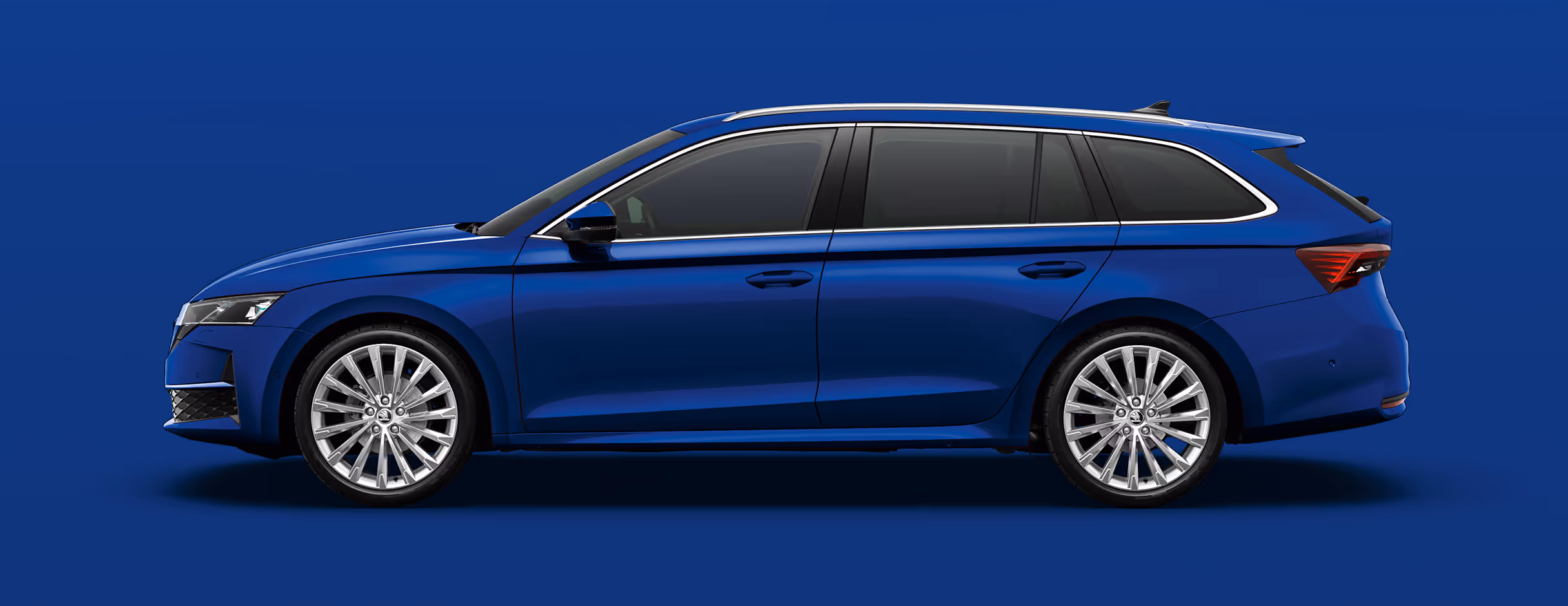 Seitenansicht eines Škoda Elroq in der Farbe Race-Blau Metallic mit 20 Zoll Leichtmetallfelgen “Vega” vor einem einfarbigen Hintergrund im Farbton der Fahrzeuglackierung.