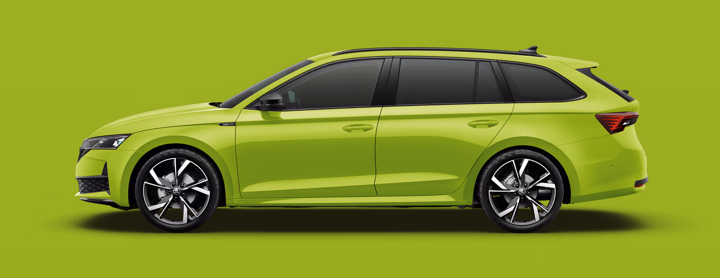 Seitenansicht eines Škoda Octavia RS Combi in der Lackierung Mamba-Grün mit 19 Zoll Leichtmetallfelgen “Draconis glanzgedreht schwarz” vor einem einfarbigen Hintergrund in der Farbe der Fahrzeuglackierung.
