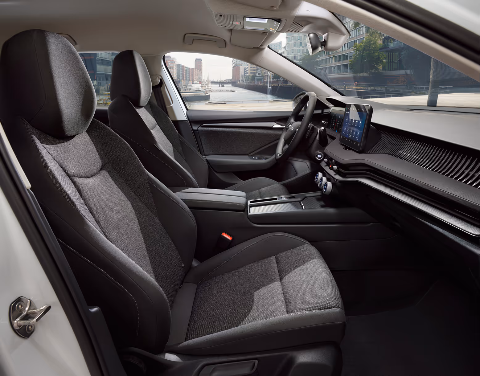 Beifahrer-Perspektive im Innenraum des Škoda Elroq in der Ausstattungslinie “Studio”. Der Blick fällt auf das Lenkrad, das Digital Cockpit und den zentralen Infotainment-Bildschirm.