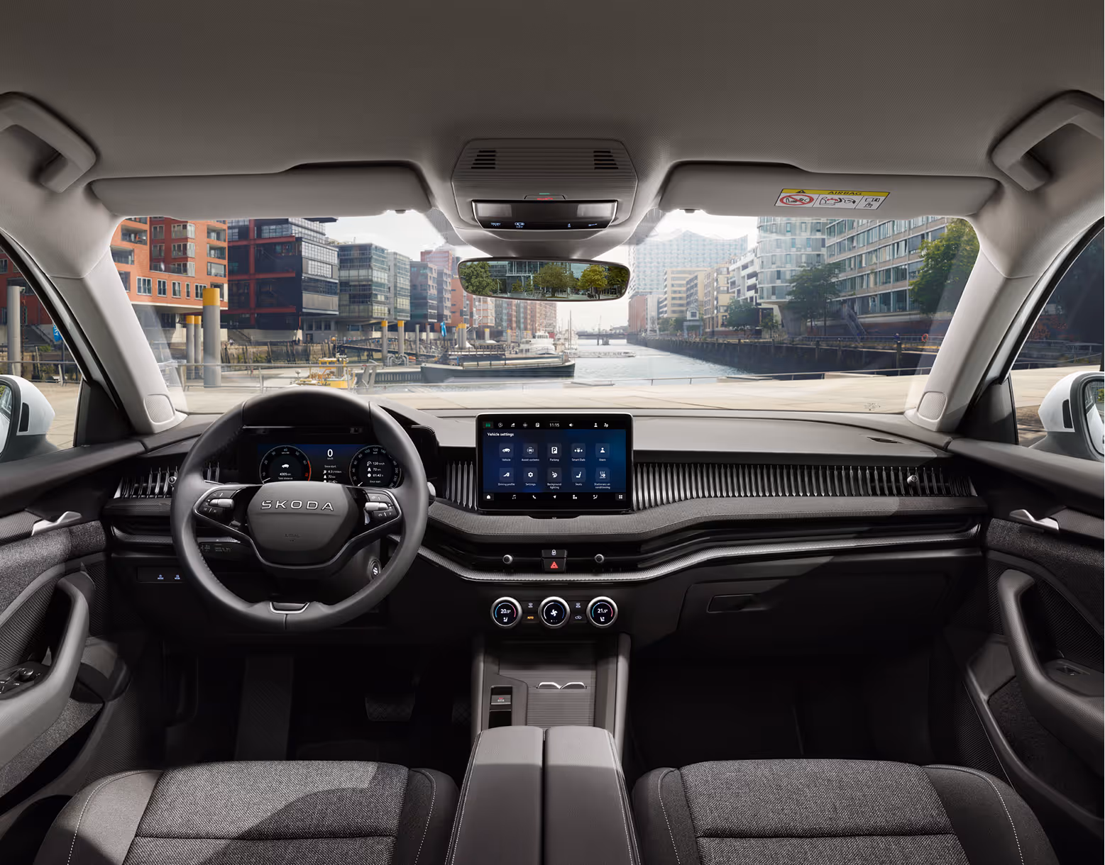 Blick über die Mittelarmlehne auf das Infotainmentsystem im Škoda Elroq mit der Ausstattungslinie “Studio”.