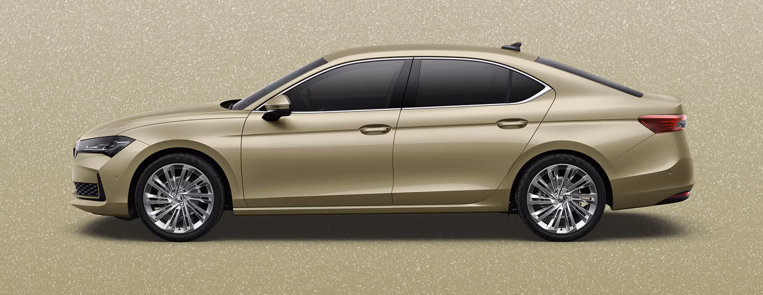 Seitenansicht einer Škoda Superb Limousine in der Lackierung Ice Tea-Beige Metallic mit 19 Zoll Leichtmetallfelgen “Veritate” vor einem einfarbigen Hintergrund in der Farbe der Fahrzeuglackierung.