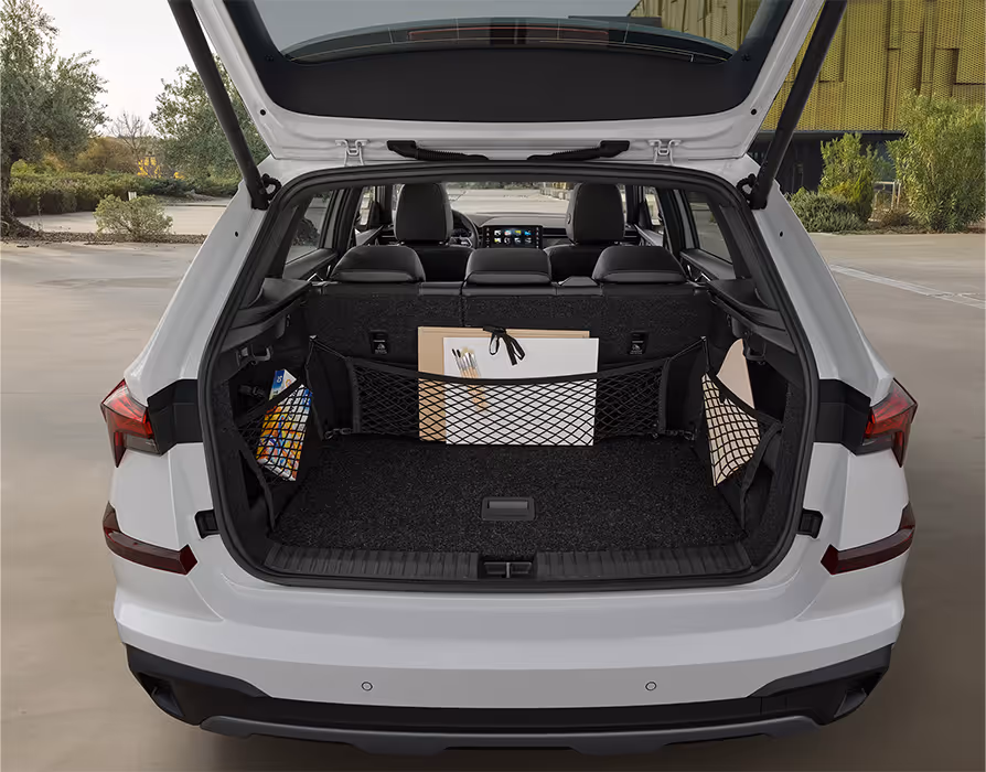 Eine Ansicht des geöffneten Kofferraums eines Škoda Kamiq zeigt die Anwendung des Netzprogramms. Verschiedene schwarze Netze an der Rücksitzlehne und an den Seiten sichern diverse Gegenstände wie Künstlerbedarf und Zeitschriften.