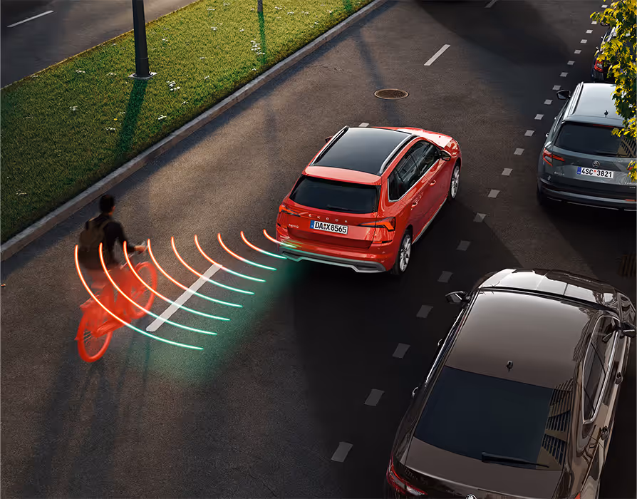 Animation des Spurwechselassistenten: Aus dem toten Winkel nähert sich von der linken Seite ein Fahrradfahrer dem roten Škoda Kamiq. Das System warnt vor der möglichen Gefahrensituation.