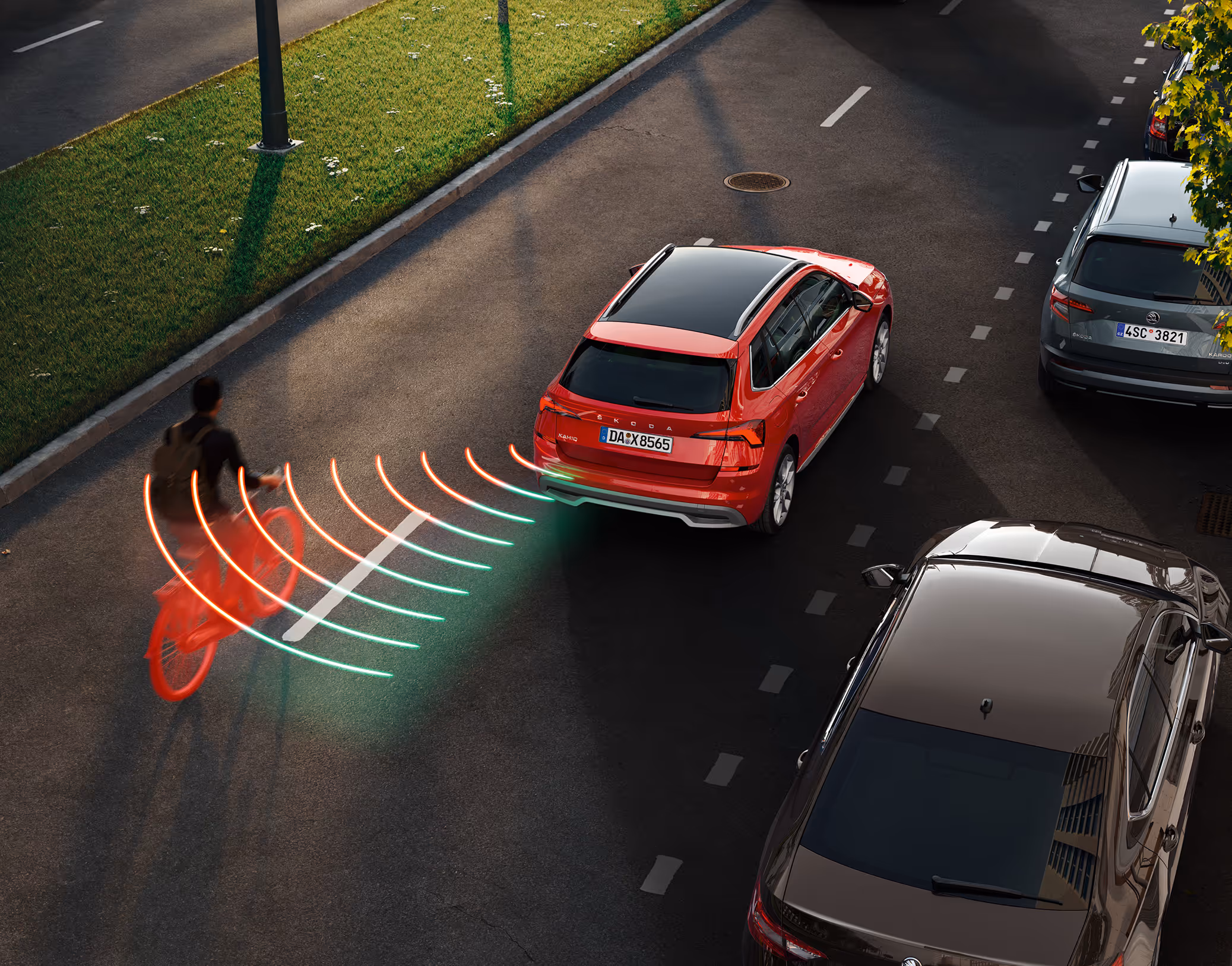 Animation des Spurwechselassistenten: Aus dem toten Winkel nähert sich von der linken Seite ein Fahrradfahrer dem roten Škoda Kamiq. Das System warnt vor der möglichen Gefahrensituation.