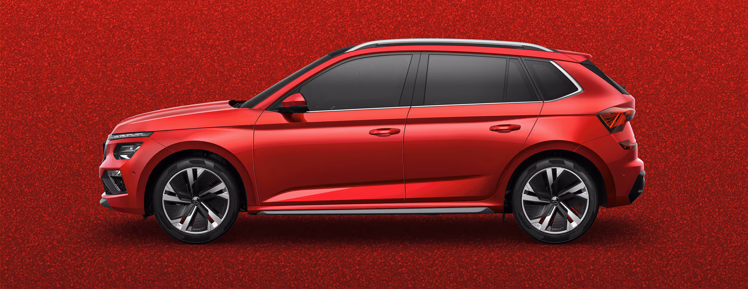 Seitenansicht eines Škoda Kamiq in der Lackierung Velvet-Rot Metallic mit 18 Zoll Leichtmetallfelgen “Ursa” vor einem einfarbigen Hintergrund in der Farbe der Fahrzeuglackierung.