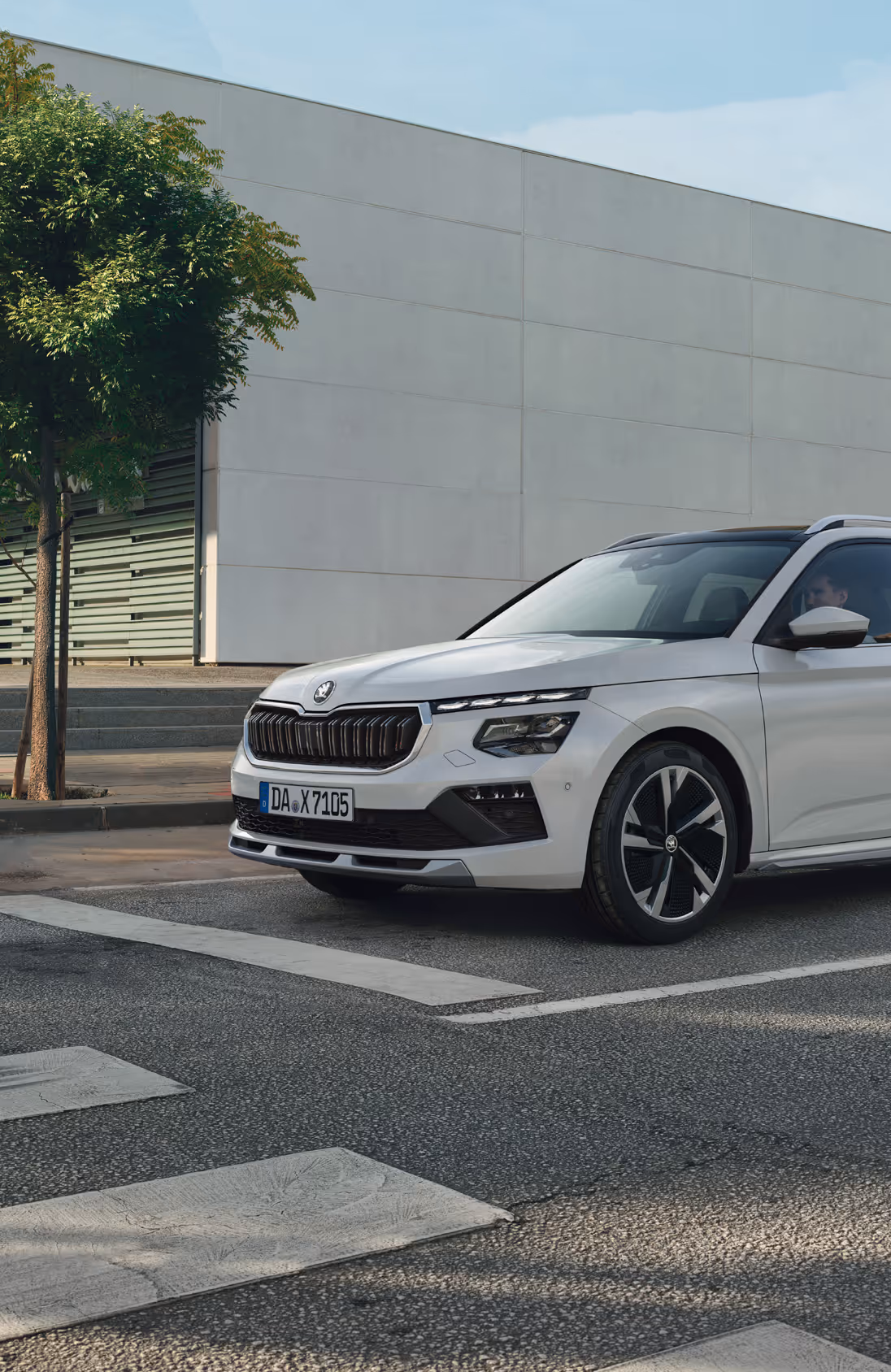 Frontalansicht des Škoda Elroq in der Farbe Timiano-Grün vor einem grünen Studiohintergrund. Die LED-Matrix-Scheinwerfer des Fahrzeugs leuchten und betonen das moderne Design der Frontpartie.