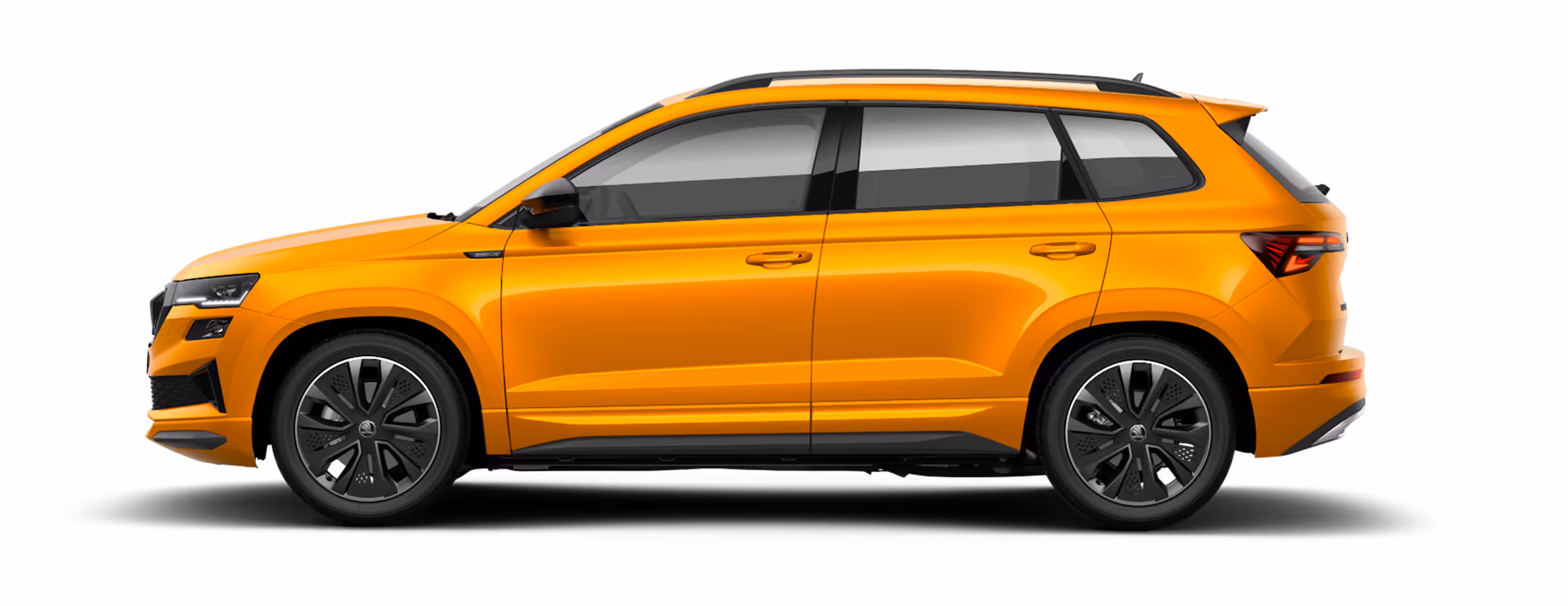 Seitenansicht eines freigestellten Škoda Karoq Sportline in der Lackierung Phoenix-Orange Metallic mit 18 Zoll Leichtmetallfelgen “Procyon schwarz glanzgedreht".