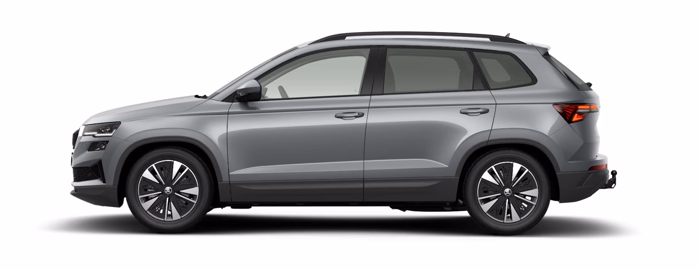 Seitenansicht eines Škoda Karoq in der Lackierung Smokey Diamond-Silber Metallic mit 17 Zoll Leichtmetallfelgen “Scutus” vor einem einfarbigen Hintergrund in der Farbe der Fahrzeuglackierung.
