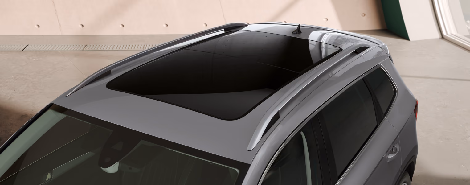 Innenraum des Škoda Elroq RS mit Blick auf das Lenkrad und den freistehenden 13-Zoll-Infotainmentbildschirm. Das Interieur ist mit schwarzem Kunstleder und Suedia Microfaser sowie grünen Ziernähten und Carbon-Dekorleisten gestaltet.