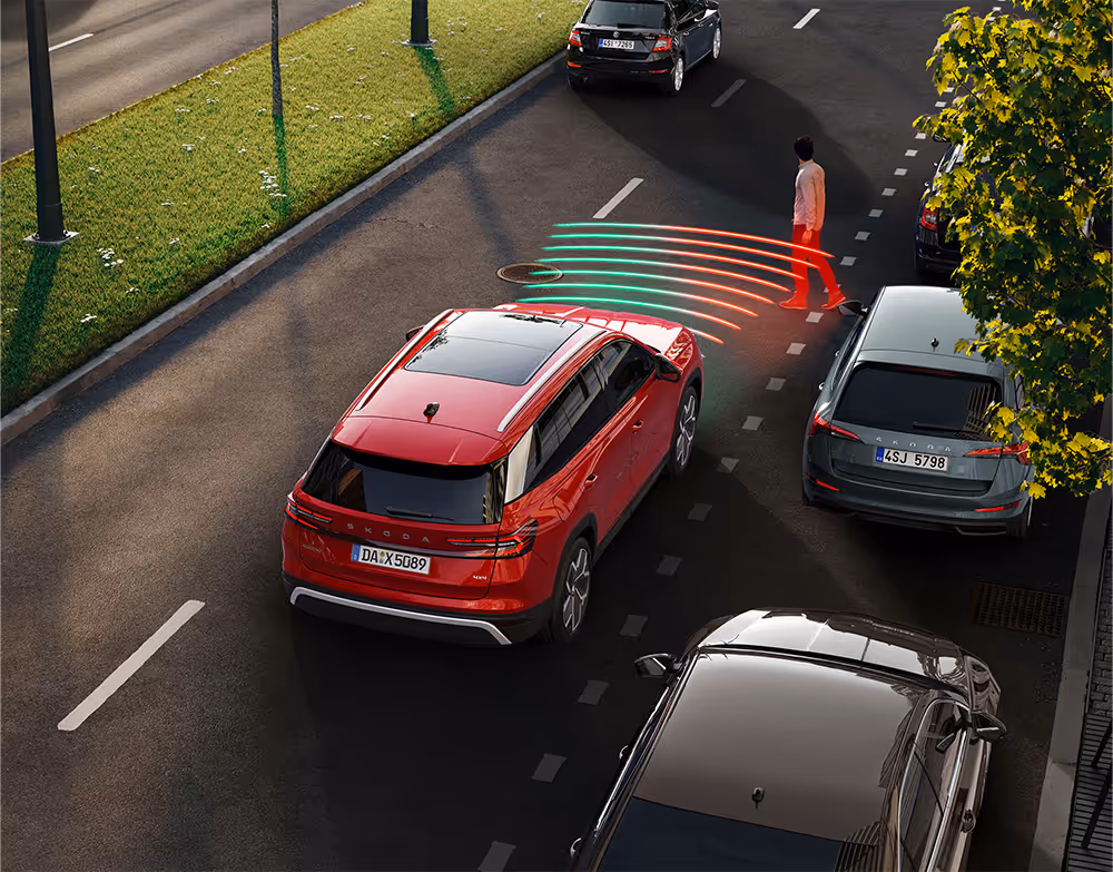 Animation des Frontrad- und Ausweichassistenten. Der rote Škoda Kodiaq fährt die Straße entlang. Plötzlich überquert ein Fußgänger, der aus einem schwer einsehbaren Bereich kommt, die Straße. Das System warnt.