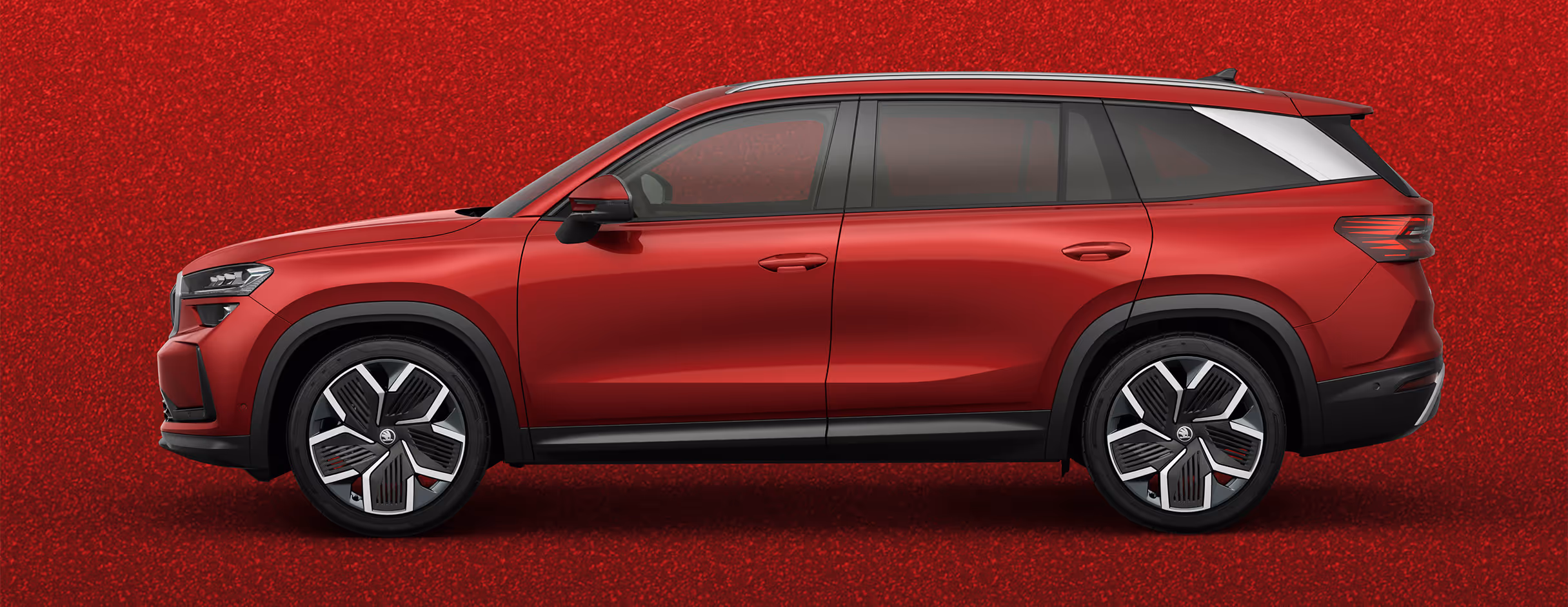 Seitenansicht eines Škoda Kodiaq in der Lackierung Velvet-Rot Metallic mit 20 Zoll Leichtmetallfelgen “Rila Aero” vor einem einfarbigen Hintergrund in der Farbe der Fahrzeuglackierung.