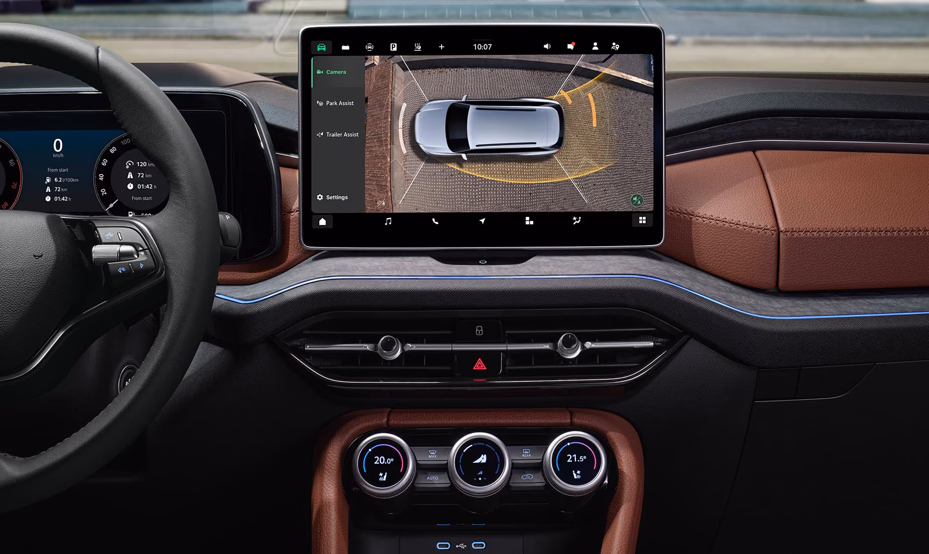 Eine Nahaufnahme des Außenspiegels eines Škoda Kodiaq in Gold-Bronze Metallic spiegelt eine Szene im Fahrzeuginneren wider. In der Spiegelung ist ein Paar zu sehen, das in den cognac-braunen Ledersitzen der Design Selection Lounge sitzt, während die Beifahrerin etwas am Dachhimmel einstellt. Unter rechts steht auf einer dunkelgrün abgesetzten Fläche geschrieben: "Sicherheit und Assistenten"
