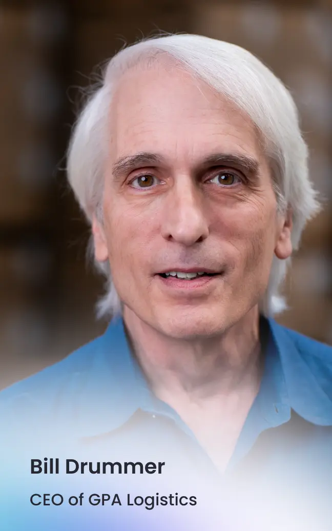Portrait of Bill Drummer, CEO of GPA Logistics, with white hair and wearing a blue shirt.