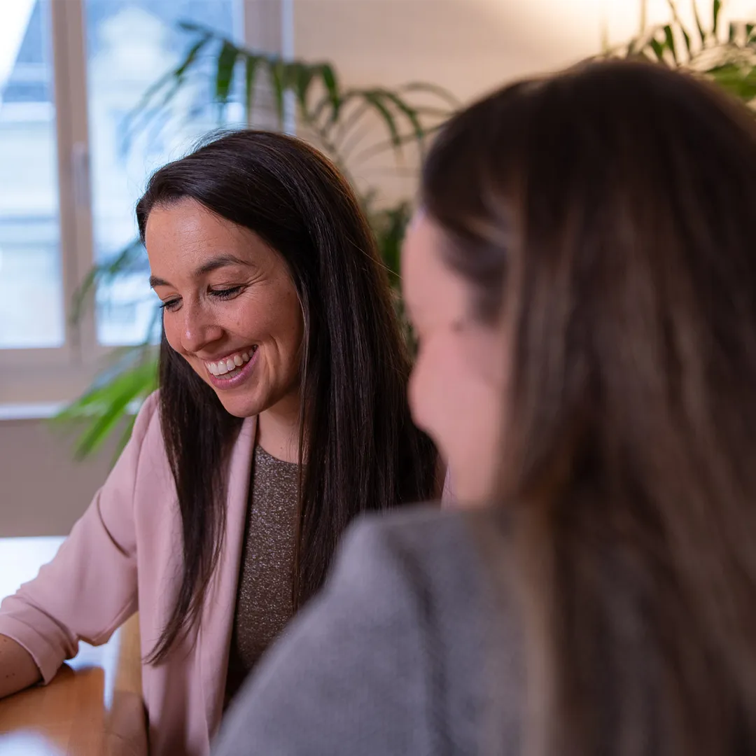 Carina Messmere lacht, während sie mit einer Kundin spricht.