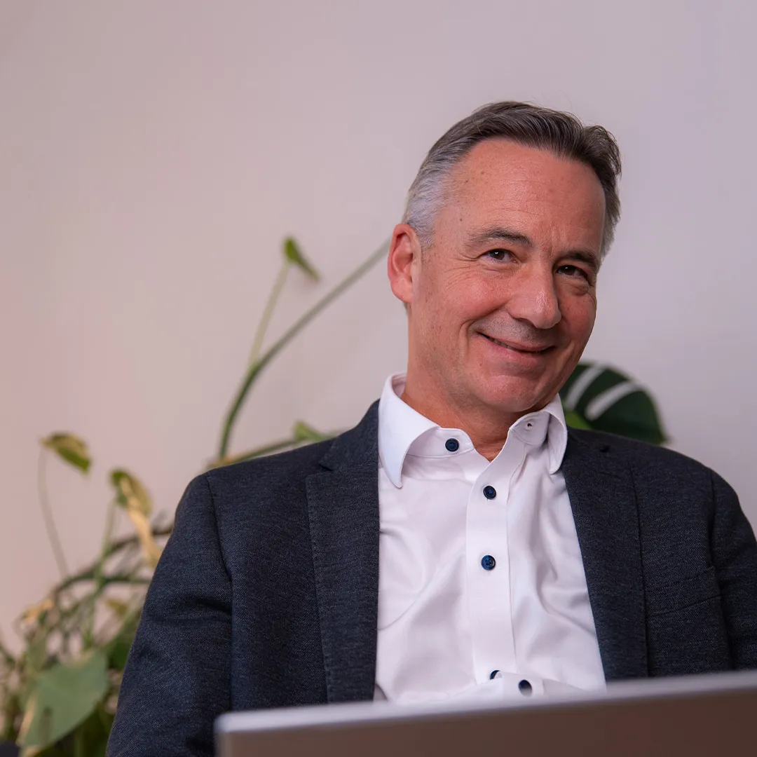 Roman Wider der in die Kamera lächelt.