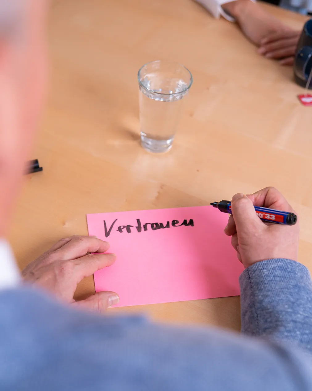 Carina Messmer und Roman Wider stehen an einem Schreibtisch und besprechen etwas.