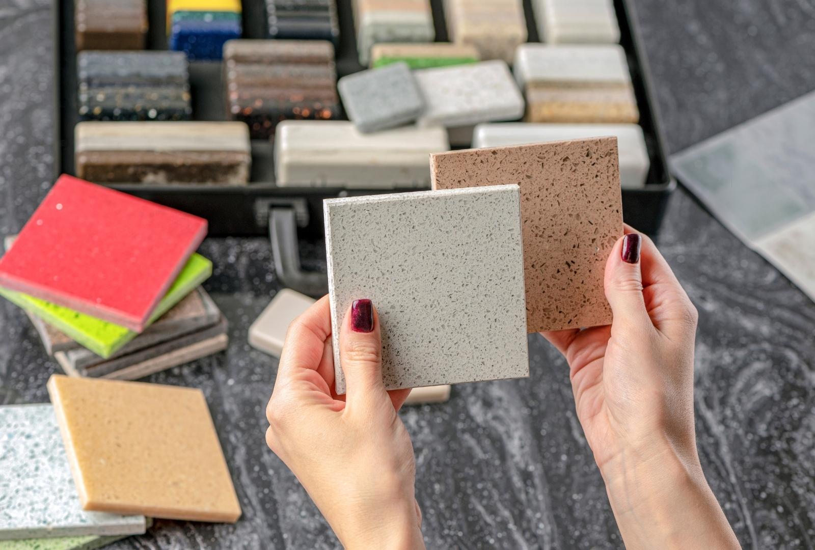 Choice of Tiles. Female Hands Hold Samples of Tiles of Different Colors. Woman in Store Chooses Bathroom Tiles.