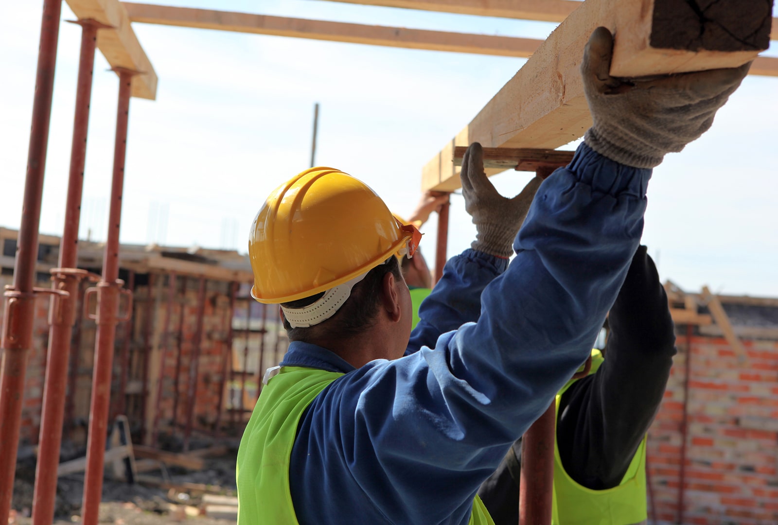 A construction worker lifting a wood