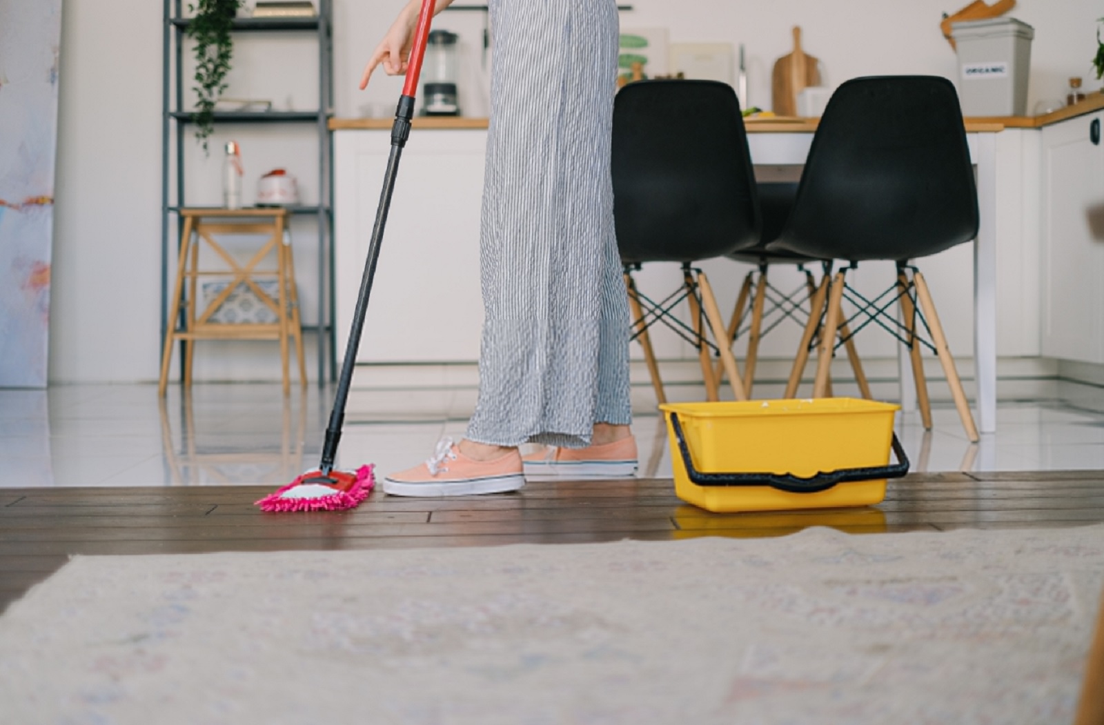 A woman cleaning the floor with a mop.