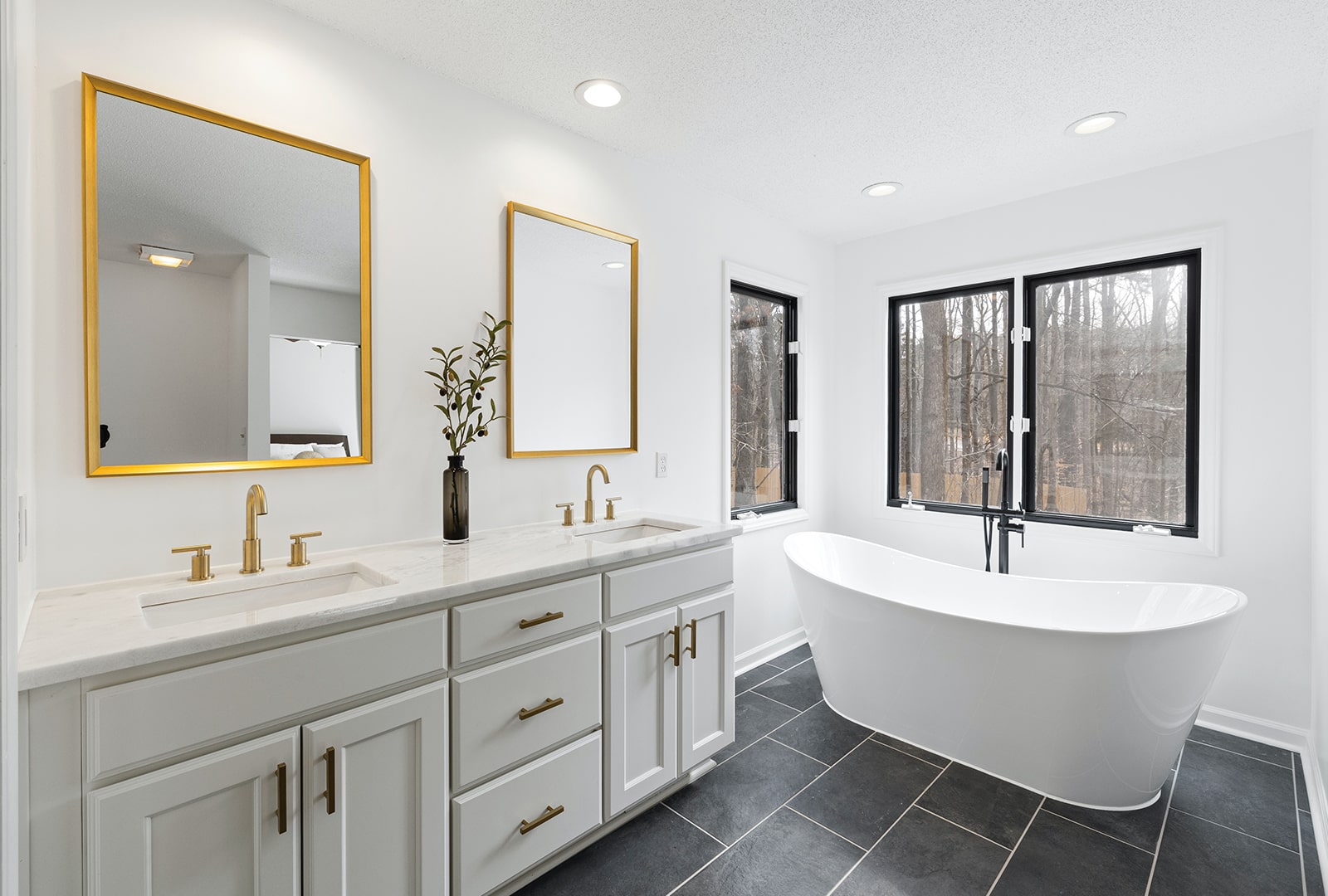An elegant white bathroom with large vanity mirrors.