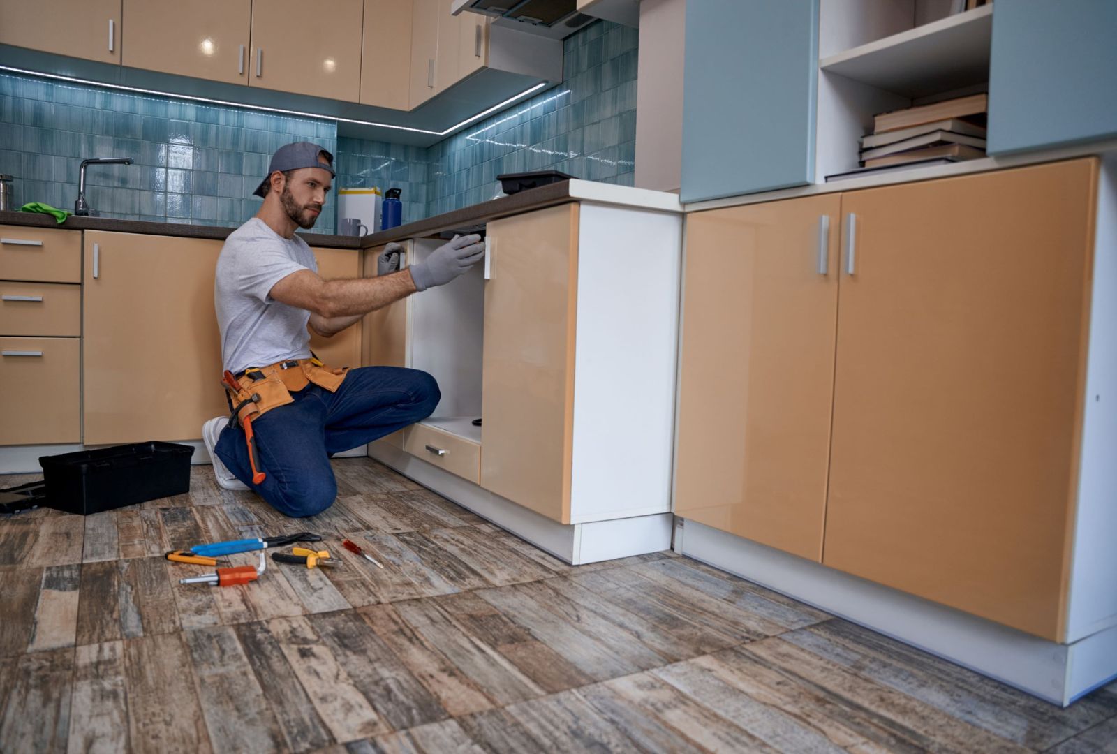 young caucasian worker measuring drawer in kitchen furniture