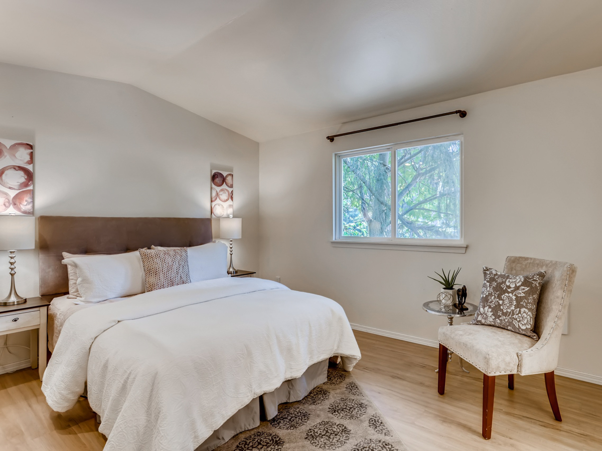 Serene bedroom in a modern coastal home with neutral tones, white bedding, soft lighting, and minimalist décor creating a calm, relaxing retreat.