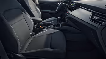 Eine Nahaufnahme zeigt den Beifahrersitz eines Škoda Scala mit der Design Selection Studio. Die Sitzbezüge sind aus schwarzem Stoff gefertigt und werden durch graue Stoffeinsätze an den Seitenwangen sowie helle Kontrastnähte akzentuiert.