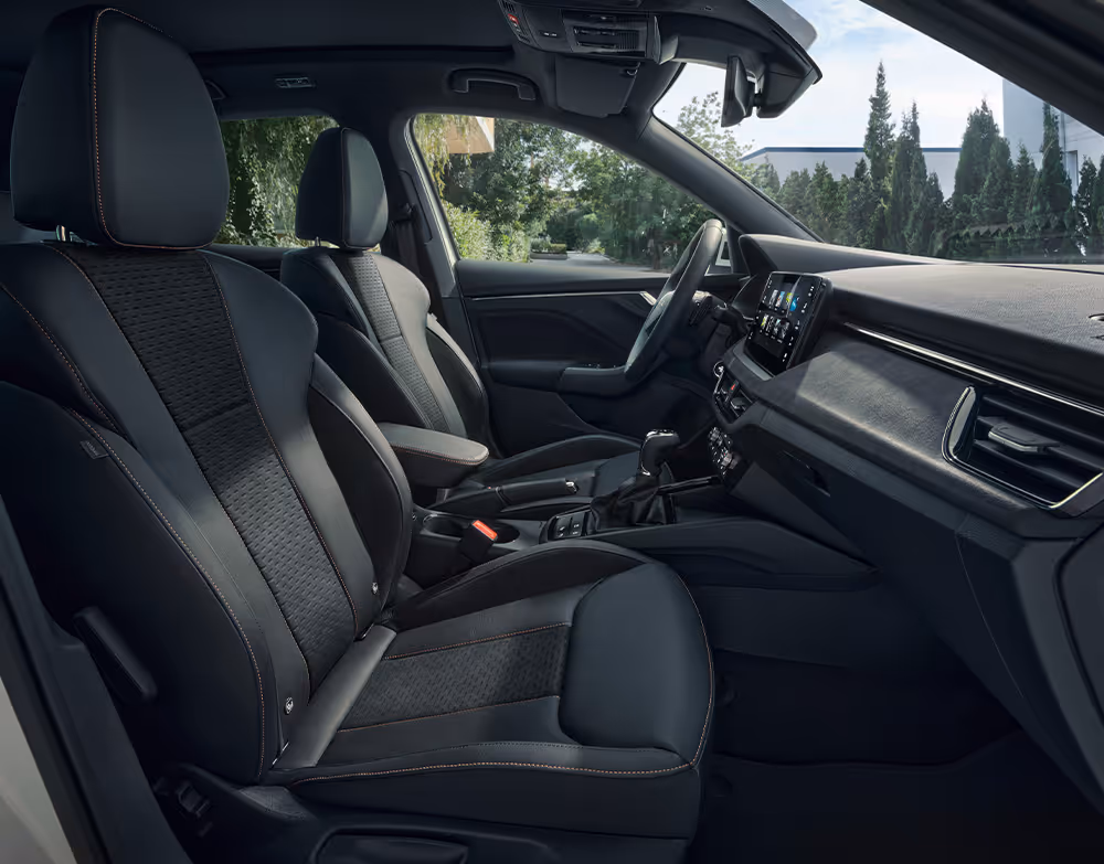 Eine seitliche Innenansicht des Škoda Scala zeigt die Vordersitze und das Cockpit mit der Design Selection Suite. Die Sitzbezüge kombinieren schwarzes Leder mit hochwertigem Microfaser-Stoff und werden durch kupferfarbene Kontrastnähte stilvoll akzentuiert.