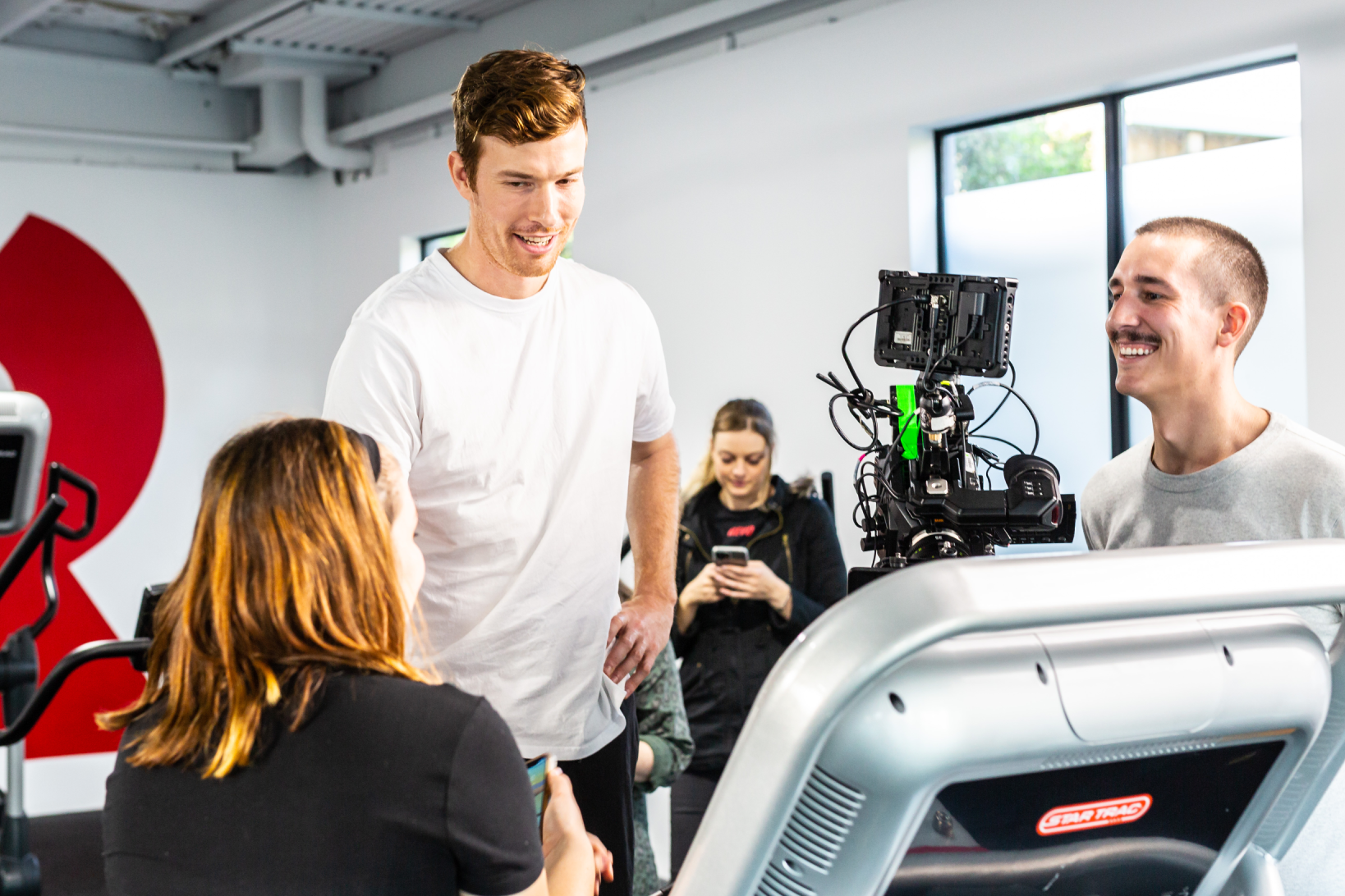 A set of people in a studio conversing and laughing.